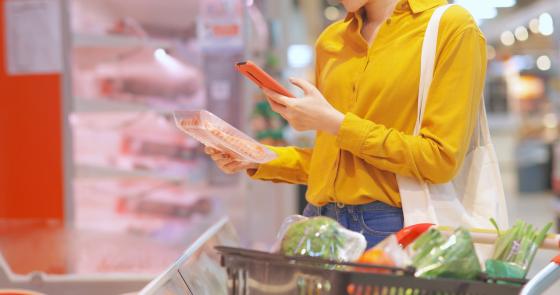 Woman grocery shopping scanning items with phone